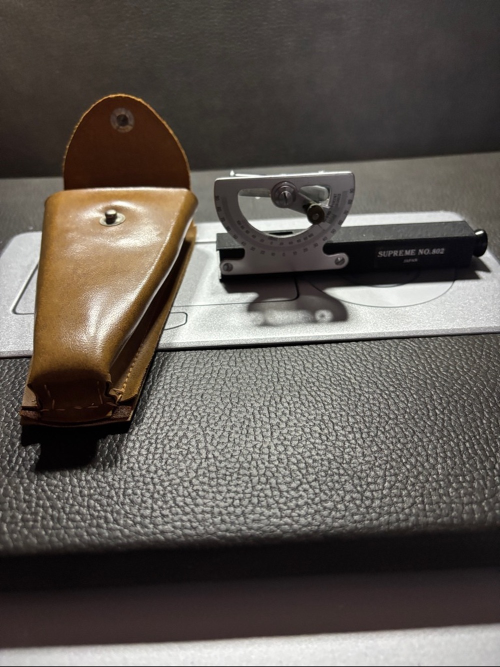 A Supreme No. 802 inclinometer with a leather carrying case.